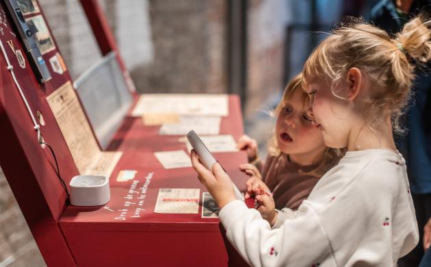 Twee meisjes bekijken kaartjes in een expo