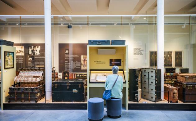 Een dame zit op een stoel in een museumzaal