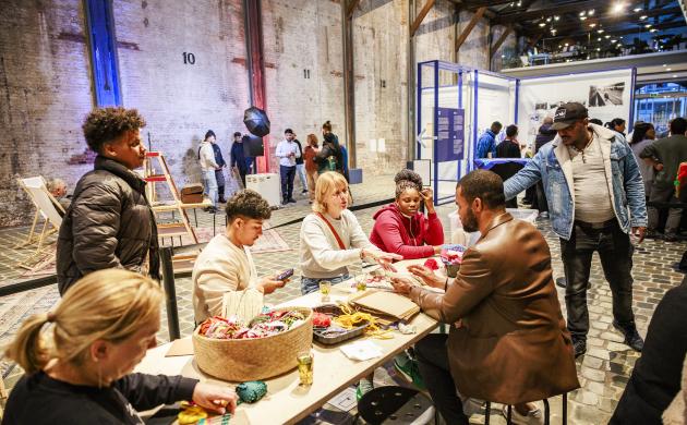 Een groep mensen aan een tafel knutselt